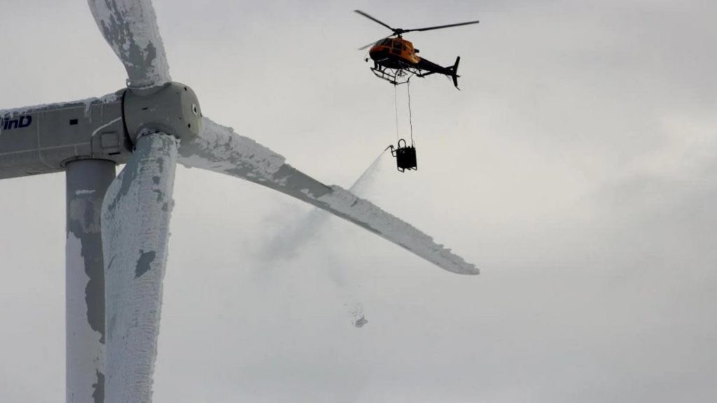 Helicopter attempts to de-ice turbine blade on Swedish wind turbine.