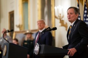 President Donald J. Trump listens as Senator Steve Daines, R-Mont., delivers remarks