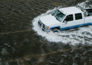 White crew cab truck navigating flood.