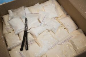 Plastic bags with cocaine are in a cardboard package box