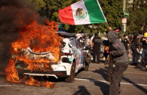 Protest Scene with Burning Car and Mexican Flag