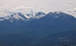 Snow-Capped Mountain Range Under Cloudy Sky