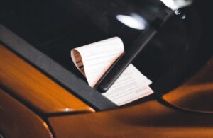 Close-up of a parking ticket on a car windshield at night, highlighting urban parking issues.