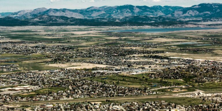 The scenic landscape of Helena, Montana with vast fields and mountain views.