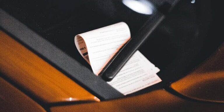 Close-up of a parking ticket on a car windshield at night, highlighting urban parking issues.