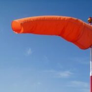Photo by Bluesnap windsock, bright, orange, blue sky, air sleeve, air sock, wind cone, red, white, pole, wind, blowing, windsock, windsock, windsock, windsock, windsock