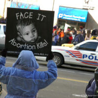 A pro-life demonstrator holds a sign reading “Face It, Abortion Kills!” outside a Planned Parenthood clinic A pro-life demonstrator holds a sign reading “Face It, Abortion Kills!” outside a Planned Parenthood clinic