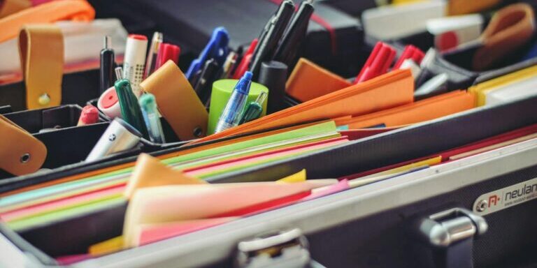 A collection of colorful office supplies neatly arranged in a suitcase, perfect for professionals on the go.