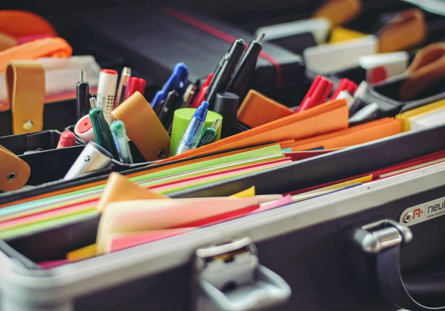 Photo by Tim Gouw A collection of colorful office supplies neatly arranged in a suitcase, perfect for professionals on the go.