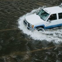 White crew cab truck navigating flood. White crew cab truck navigating flood.