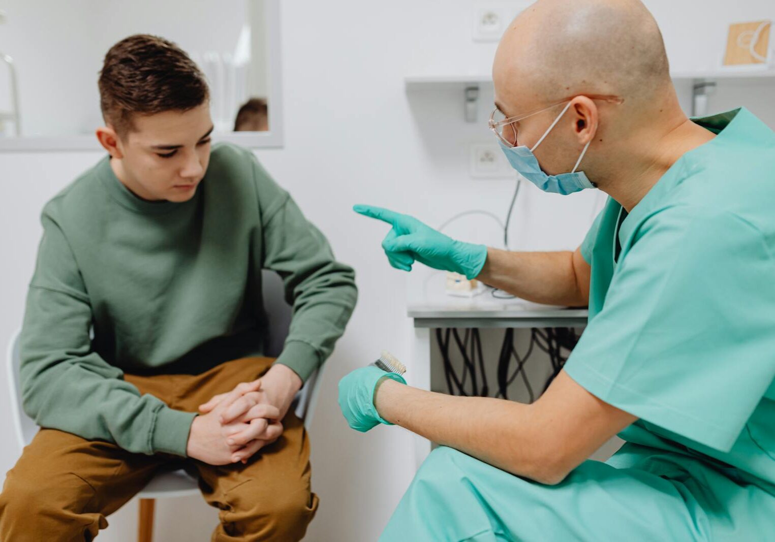 A teenager consults a doctor in a clinic, discussing health concerns.