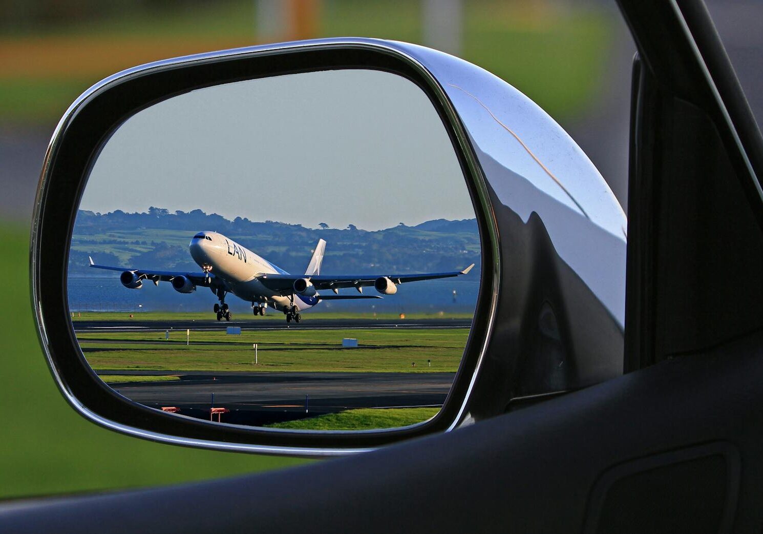 Photo by Pixabay A jet airplane taking off is reflected in a car's side mirror, capturing a unique aviation perspective.