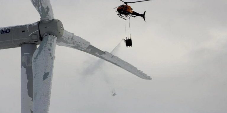 Helicopter attempts to de-ice turbine blade on Swedish wind turbine.