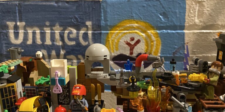Lego Meth Lab in front of United Way logo. Photo by Travis Mateer for Western Montana News. 