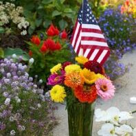 A vase of flowers with an American Flag placed at the UM Oval memorial site for Charlie Kirk A vase of flowers with an American Flag placed at the UM Oval memorial site for Charlie Kirk
