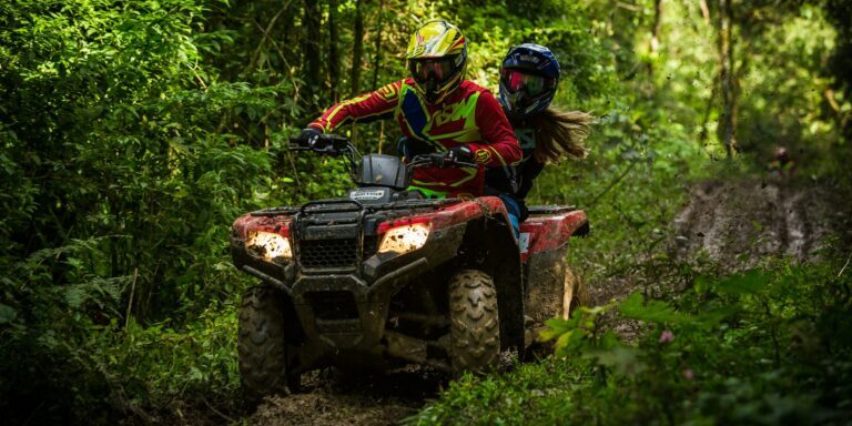 man and woman riding on ATV