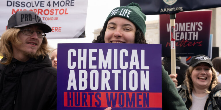 Young woman holds "Chemical Abortion Harms Women" sign outside SCOTUS during Pro-Life rally