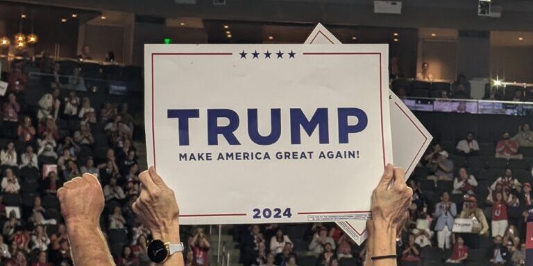 2024 RNC Convention attendee holds Trump sign