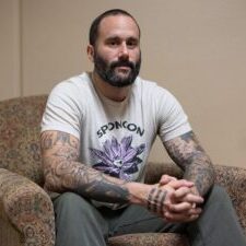 Tattooed Man Sitting on an Armchair