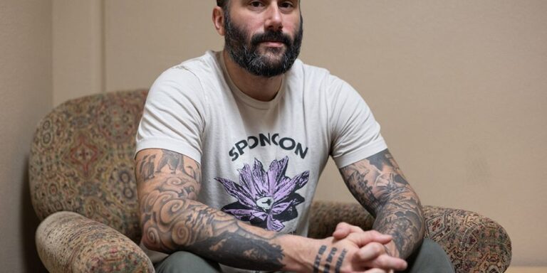 Tattooed Man Sitting on an Armchair