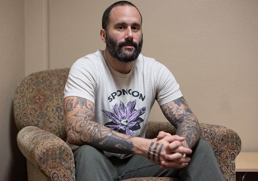 Tattooed Man Sitting on an Armchair