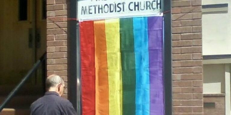 Missoula First United Methodist Church hangs "Pride Flag" outside Main Street entrance for "Pride Week." <a href="https://www.facebook.com/1stumcmissoula/photos/a.803756212981242/944913075532221">MFUMC Facebook, June 2015</a>.