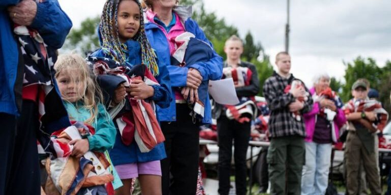 Nora Kappelman, 5, left, and sister Sophia Kappelman, 9, wait in line to dispose of unserviceable flags during an American Legion Post 27 ceremony on Flag Day in Missoula, MT 2020. Photo by Tommy Martino/The American Legion