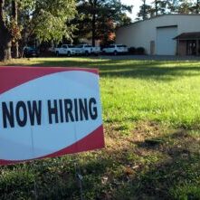 Photo by Ernie Journeys a now hiring sign in front of a building