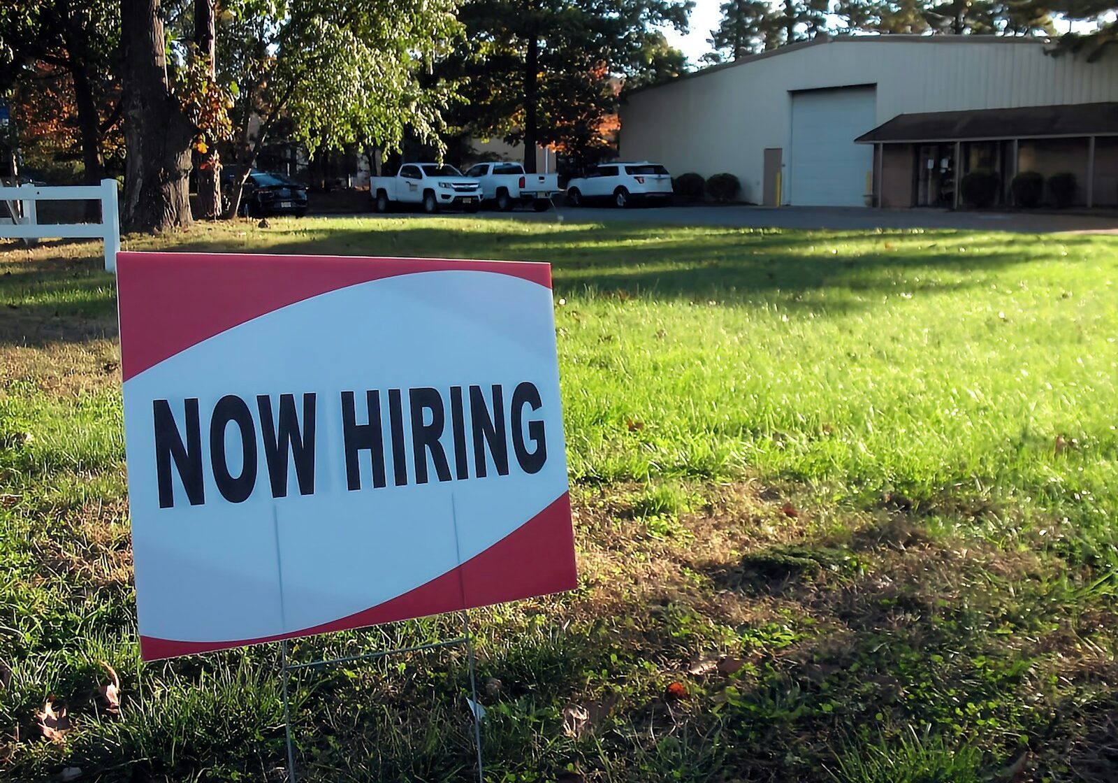 a now hiring sign in front of a building