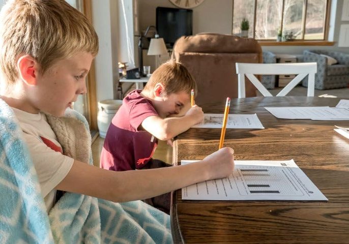 Homework at Home: Siblings Focused on Worksheets