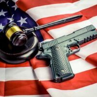 Photo by Bermix Studio a gun, a judge's hammer, and an american flag