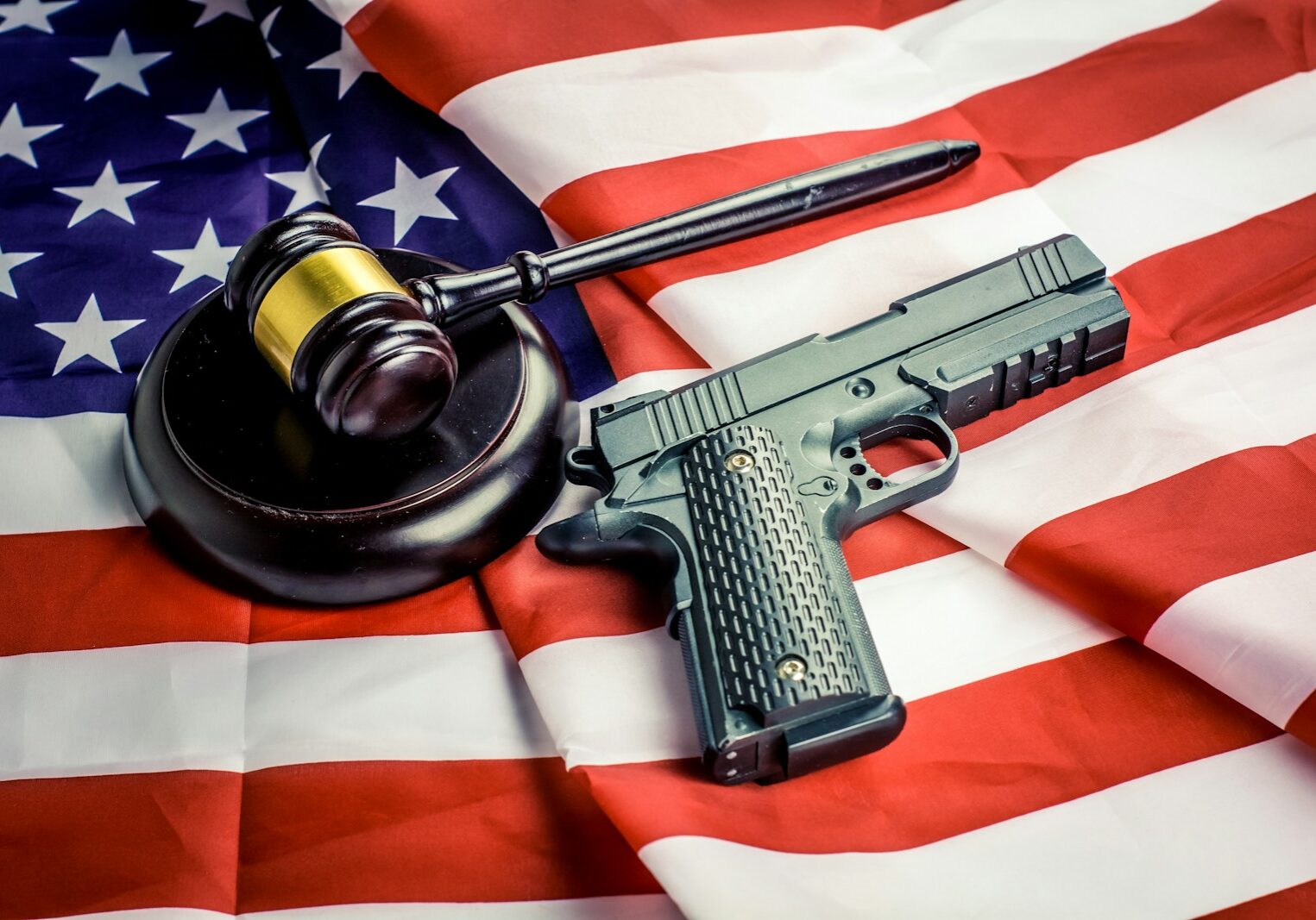 Photo by Bermix Studio a gun, a judge's hammer, and an american flag