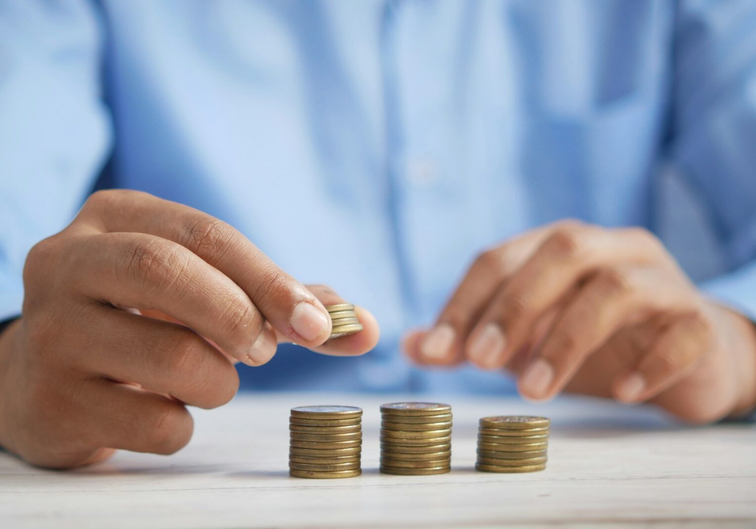 Photo by Towfiqu barbhuiya a person stacking coins on top of a table