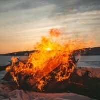 a fire burning in the middle of a snow covered field