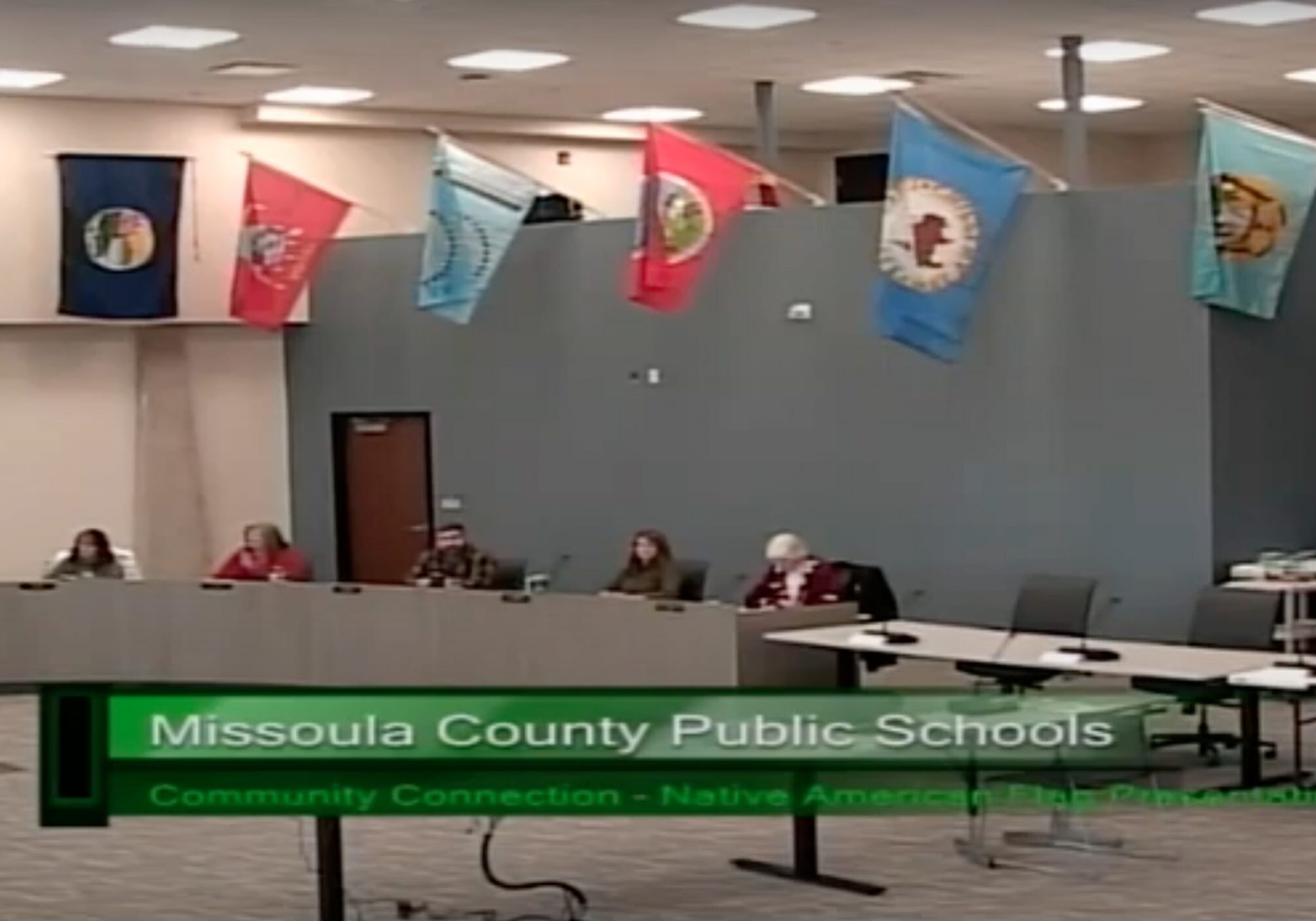 Indigenous National flags hang over Missoula school board trustees during their April 26, 2022 meeting.