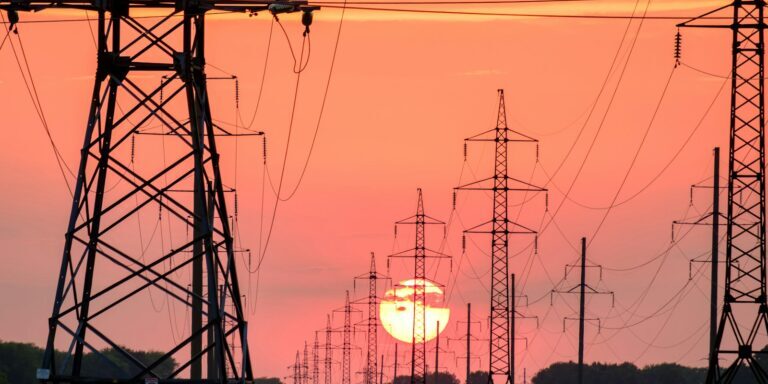 silhouette of electric post during sunset