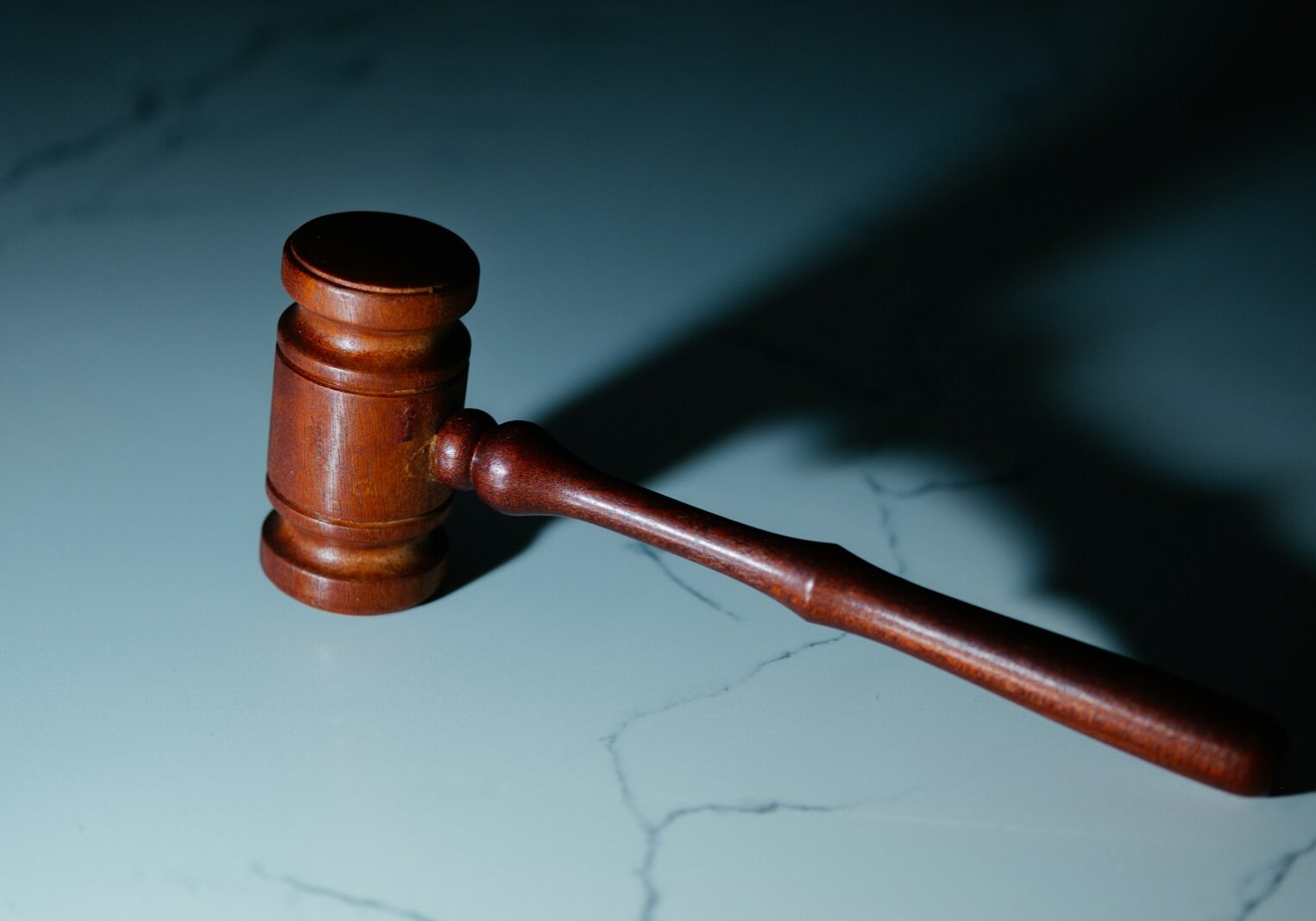 Photo by Wesley Tingey a wooden judge's hammer sitting on top of a table