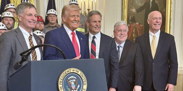 Montana Governor Greg Gianforte stands with President Trump and coal workers