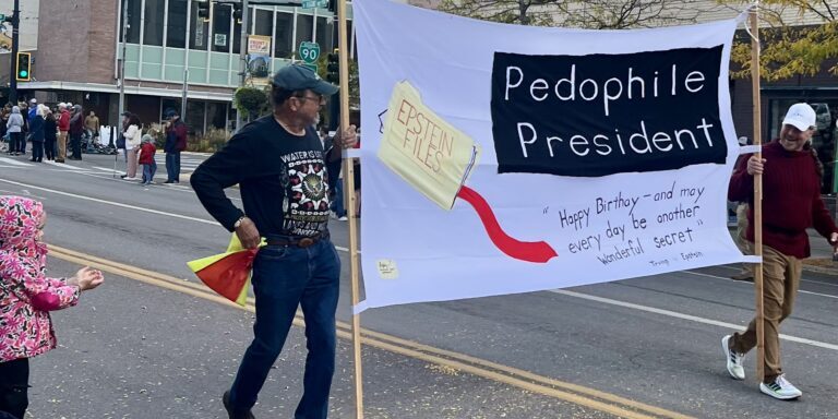 Protest Banner at Street Parade Addressing Political Controversy