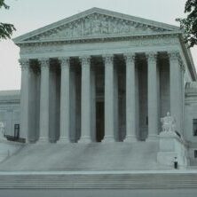Photo by Malcolm Hill Front view of the iconic Supreme Court building with classical columns and majestic architecture.