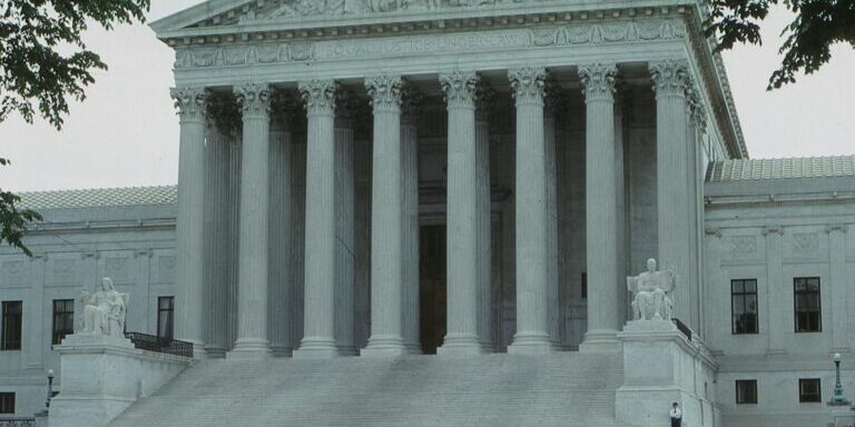 Front view of the iconic Supreme Court building with classical columns and majestic architecture.