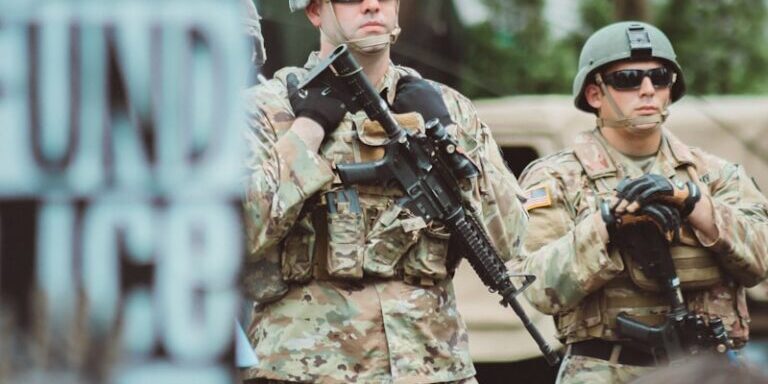 man in brown and black camouflage uniform holding rifle