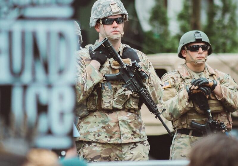 man in brown and black camouflage uniform holding rifle