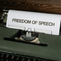 a typewriter with a paper that reads freedom of speech