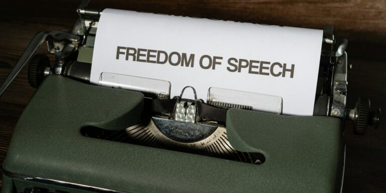 a typewriter with a paper that reads freedom of speech