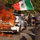 Protest Scene with Burning Car and Mexican Flag